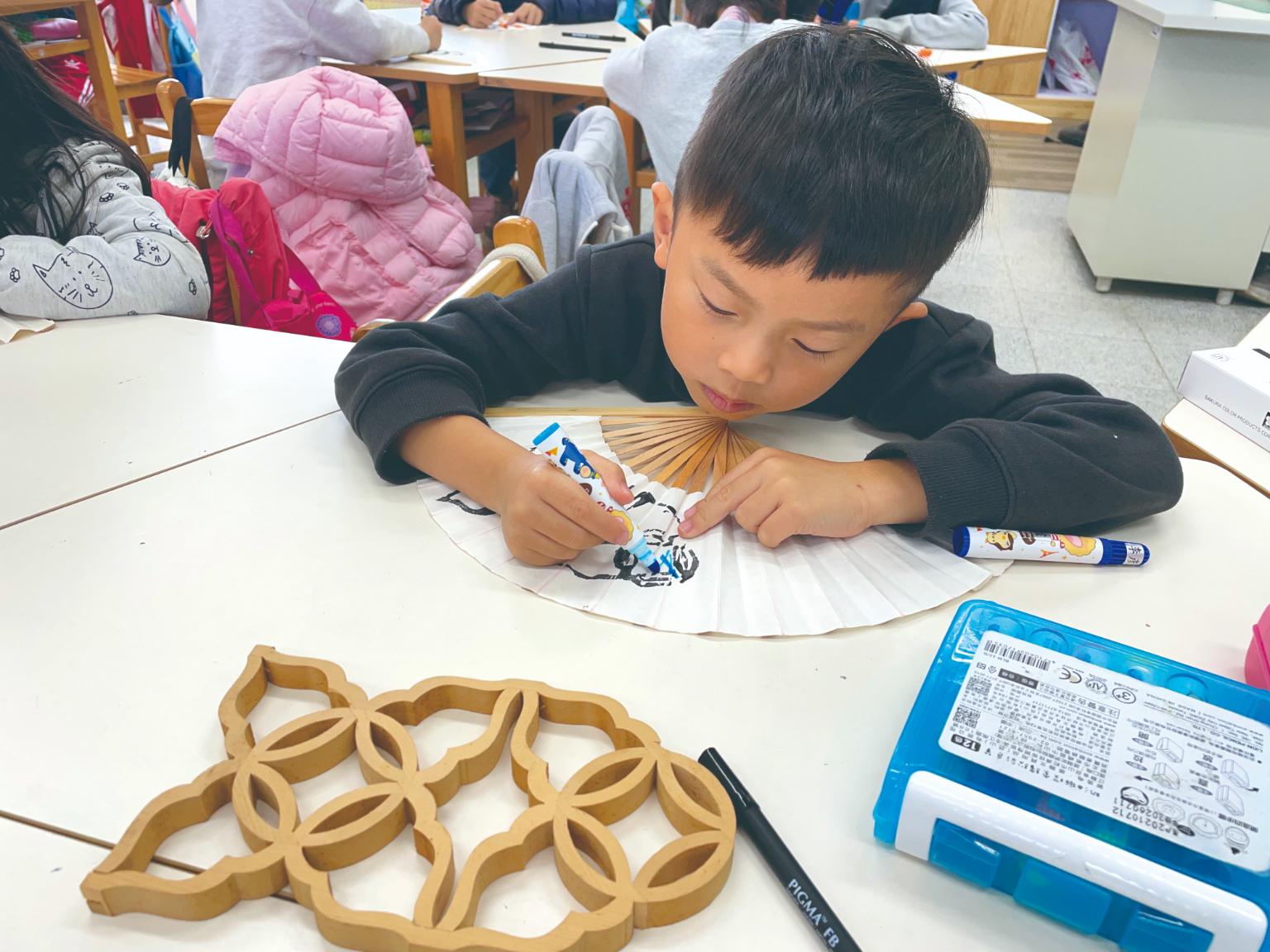 孩子們以窗花木雕美學創作摺扇／鹿江國際中小學提供。